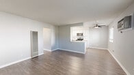 Located at 5800 South St. in Lakewood, California, this single-story residence offers two bedrooms and two bathrooms within a thoughtfully designed floor plan. The open-concept living room is bright and welcoming, featuring wood-look vinyl flooring, soft neutral gray walls, a textured ceiling, and multiple windows that invite natural light and outdoor views. A wall-mounted air conditioning unit provides convenient climate control throughout the main living area.

The kitchen is efficiently laid out with crisp white cabinetry extending to the ceiling, light quartz-style countertops, and a full suite of stainless steel appliances including a gas range, microwave, and refrigerator. Wood-look flooring continues seamlessly from the living area into the kitchen.

Both bedrooms continue the neutral color palette with the same durable wood-look flooring and are each equipped with ceiling fans for added comfort. The primary bedroom features a sliding-door closet and a window with natural light. The second bedroom offers a clean, versatile space.

The two bathrooms are finished in a clean, functional style. One features a tub-shower combo with white tile surround and brushed gold fixtures, while the other includes a tub-shower with a curved rod, a quartz-topped vanity, and wood-look flooring. A hallway connects all rooms, completing this well-organized and move-in ready home.