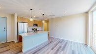 Located at 295 E Las Animas St in Colorado Springs, CO, this thoughtfully designed one-bedroom, one-bathroom residence offers a modern, efficient layout across a single floor. The open-concept living and kitchen area serves as the heart of the home, anchored by a sleek center island with a white quartz countertop, an undermount stainless steel sink, and stylish globe pendant lighting. Light wood cabinetry lines the kitchen walls, complemented by a full suite of stainless steel appliances including a refrigerator, range, microwave, and dishwasher, all set against a clean tile backsplash. Light-toned luxury vinyl plank flooring flows throughout the main living area, enhancing the bright and airy atmosphere. A large sliding glass door opens to a private balcony, inviting natural light and neighborhood views into the space. The bedroom features plush carpet, a ceiling fan, and a window with neighborhood views, offering a quiet retreat. The bathroom is well-appointed with a tub-shower combination featuring tile surround, a wood-toned vanity with white countertop, and open built-in shelving for added storage. A dedicated closet and in-unit utility access complete this efficient and contemporary residence.