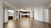 Located at 3111 S St in Sacramento, CA, this two-bedroom, one-bathroom residence offers a well-designed open-concept layout across a single floor. The living area features rich wood-style flooring and clean white walls, with large windows and a glass door that fill the space with natural light and provide outdoor views.

The kitchen is a standout feature, outfitted with rich dark-wood cabinetry extending to ceiling height, white subway tile backsplash, light countertops, and a full suite of stainless steel appliances including a French door refrigerator, electric range, built-in microwave, and dishwasher. Track lighting and recessed ceiling lights illuminate the space effectively. An in-unit stacked washer and dryer is conveniently tucked adjacent to the kitchen.

The two bedrooms are carpeted for comfort and each receive natural light through well-positioned windows. The primary bedroom includes direct outdoor access via a glass door. Both bedrooms are served by dedicated closets, with the primary closet featuring a well-organized built-in shelving and hanging system.

The bathroom is clean and functional, with a dark-wood vanity, white countertop, large mirror, tub-shower combination, and built-in open shelving for storage. Wood-style flooring continues here, tying the space together cohesively.