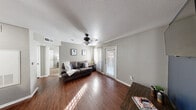 Located at 121 Clements Street in Angleton, TX, this well-appointed one-bedroom, one-bathroom residence offers a smartly organized single-floor layout designed to maximize comfort and functionality. The living room serves as the heart of the home, showcasing rich hardwood-style flooring, a ceiling fan with light fixture, and a door leading to a private balcony that fills the space with natural light. A bold navy accent wall adds a striking design element, providing a stylish backdrop for the entertainment area. The kitchen is equipped with dark cabinetry, light stone-look countertops, black appliances including a refrigerator, range, and dishwasher, and direct access to a dedicated laundry area housing an in-unit washer. The combined dining space adjoins the kitchen seamlessly, creating an open and sociable flow. The bedroom features soft carpeting, a ceiling fan, and ample natural light, complemented by multiple closets for generous storage. The full bathroom offers a clean, bright aesthetic with a tub/shower combination. Textured ceilings are found throughout, and neutral wall tones create a cohesive, move-in-ready atmosphere throughout this practical and comfortable Angleton residence.
