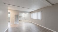 Located at 911 Pennsylvania Pl in Davis, CA, this single-floor, 2-bedroom, 2-bathroom residence offers a clean, neutral aesthetic with consistent finishes throughout. The open-concept living and dining area features light wood-style laminate flooring, a textured ceiling, large vertical-blind windows that bring in natural light, and a wall-mounted AC unit. The adjoining kitchen is well-equipped with stainless steel appliances—including a refrigerator, electric range, and over-the-range microwave—white cabinetry, stone-look countertops, a ceiling fan, tile flooring, and a window above the sink. A pantry provides additional storage. Both bedrooms feature wood-style laminate flooring, ceiling fans, natural light from windows, and mirrored sliding closet doors that enhance the sense of space. The primary bedroom is generously sized with room for a full furniture arrangement. Each bathroom is finished with tile flooring and white fixtures; one includes a tub-shower combination with grab bars, while the other features a vanity with stone-look countertops and a lighted mirror. A hallway connects the main living spaces, and two closets offer ample storage throughout the unit.