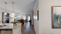 Located at 800 Wolf Ranch Pkwy in Georgetown, TX, this well-appointed 2-bedroom, 2-bathroom single-story home offers a thoughtfully designed layout ideal for comfortable living. The open-concept main area seamlessly connects the living room, dining room, and kitchen, creating an inviting and functional space. The living room features crown molding, wood-style flooring, and large windows that welcome abundant natural light. The kitchen is equipped with stainless steel appliances, dark espresso cabinetry, granite countertops, and pendant lighting, complemented by a breakfast bar for casual dining. A separate dining area with a chandelier provides an elegant setting for meals. The generously sized primary bedroom includes plush carpeting, a ceiling fan, and direct access to a private en-suite bathroom featuring dark cabinetry, granite countertops, and tile flooring. The second bedroom also offers carpeted floors, a ceiling fan, a closet, and convenient access to the adjacent bathroom. A walk-in closet with wire shelving provides excellent storage. Throughout the home, crown molding, neutral tones, and consistent finishes contribute to a clean, cohesive aesthetic that balances modern style with everyday practicality.