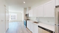 Located at 1720 Research Park Dr in Davis, CA, this thoughtfully designed one-bedroom, one-bathroom unit offers a clean, modern aesthetic across a single floor. Light wood-tone flooring runs throughout the entire space, contributing to a bright and cohesive feel.

The kitchen is a standout feature, outfitted with crisp white shaker-style cabinetry extending to the ceiling for generous storage, white subway tile backsplash, and quartz countertops. A full suite of stainless steel appliances — including a range, microwave, dishwasher, and refrigerator — provides a well-equipped cooking space that flows openly into the living area.

The spacious bedroom receives abundant natural light through a large picture window with views of the surrounding community. It connects directly to a walk-in closet equipped with dual hanging rods and shelving, offering practical storage solutions. A wall-mounted mini-split unit ensures personalized climate control.

The bathroom features a clean, minimalist design with a full soaking tub and shower combination, wood-look flooring, and a white vanity. Recessed lighting and neutral white walls throughout the unit create a bright, airy ambiance that makes the space feel open and welcoming.