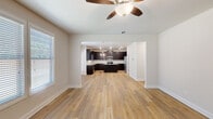 Located in Lawrenceville, GA, this well-appointed two-story home offers five bedrooms and three bathrooms across a thoughtfully designed layout. The main floor opens with a welcoming entrance and flows into a combined kitchen and living area. The kitchen is a standout feature, showcasing rich dark cabinetry, light countertops, stainless steel appliances, a central island, and an elegant chandelier — all set against warm hardwood-style flooring that extends throughout the main level. The open connection to the living room, which features a ceiling fan and abundant natural light from large windows with blinds, creates an airy, cohesive gathering space. The upper floor is home to the generously sized primary bedroom, which benefits from a triple window bank offering ample natural light and outdoor views. The spacious primary suite includes a walk-in closet with wire shelving and a private bathroom featuring dark cabinetry and granite countertops. Additional bedrooms are carpeted with neutral tones and offer outdoor views through double windows. The home also includes a dedicated laundry room with wire shelving and utility hookups, multiple hallways with tall ceilings, and four closets providing abundant storage throughout.