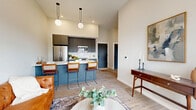 Located at 137-145 N Chestnut St in New Paltz, NY, this thoughtfully designed one-bedroom, one-bathroom residence offers a modern aesthetic across a single floor. The kitchen is a standout feature, outfitted with flat-front gray cabinetry extending to the ceiling, white quartz countertops, a white subway tile backsplash, and a full suite of stainless steel appliances including a French door refrigerator, electric range, and over-the-range microwave. A peninsula with seating provides additional prep space and casual dining. Light wood-look flooring runs throughout, creating a warm, cohesive feel. The bathroom is cleanly designed with floor-to-ceiling white tile, a glass-enclosed walk-in shower with matte black fixtures, a wall-mounted sink, and a framed mirror. The bedroom is a calm retreat, featuring tall ceilings, a wall-mounted mini-split system, and a large gridded window that draws in natural light and outdoor views. Charcoal gray interior doors with matte black hardware add a refined contrast to the neutral palette throughout. The overall ambiance is clean, contemporary, and functional — well-suited for everyday living in the heart of New Paltz.