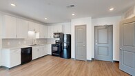Located at 366 E Broad St in the heart of Columbus, Ohio, this single-floor unit offers a thoughtfully designed open-concept layout with a clean, contemporary aesthetic. Light wood-tone luxury vinyl plank flooring flows throughout the main living areas, complemented by crisp white walls and recessed lighting that create a bright, welcoming ambiance.

The kitchen is well-appointed with white shaker-style cabinetry, a white tile backsplash, a double sink, and a full suite of black appliances including a refrigerator, range, microwave, and dishwasher. The open design allows the kitchen to connect seamlessly to the spacious living area, which benefits from large windows and a sliding glass door that floods the space with natural light and provides views of the surrounding Columbus skyline.

The bedroom is carpeted for added comfort and features its own sliding glass door with city views, offering a bright and airy retreat. A generously sized walk-in closet with wire shelving system provides ample storage. The bathroom is finished with wood-look flooring, a white vanity with an integrated sink, and a glass-enclosed walk-in shower. Multiple interior doors, including a dedicated entry door, complete the functional layout of this well-designed urban residence.