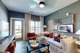 Located at 2700 N Lake Forest Dr in McKinney, TX, this thoughtfully designed 2-bedroom, 2-bathroom residence offers a well-organized single-story layout with a warm, contemporary aesthetic throughout. The open-concept living, dining, and kitchen area serves as the heart of the home, bathed in natural light from large windows with views of the surrounding community. The living room features a ceiling fan, bold accent walls in muted teal and blue tones, and direct access to an outdoor area. The kitchen is finished with light wood cabinetry, white quartz countertops, stainless steel appliances including a side-by-side refrigerator, a deep undermount sink with a matte black faucet, and gold pendant lighting. A dedicated dining area with built-in shelving completes the common living space. The primary bedroom is a serene retreat with a ceiling fan, warm-toned accent walls, natural light, and a walk-in closet outfitted with multi-level wire shelving. Its en-suite bathroom includes dual vanities with light wood cabinetry, a glass-enclosed walk-in shower with tile surround, and matte black hardware. The second bedroom echoes similar warmth with deep, rich wall tones. Additional highlights include four closets, a pantry, laundry, and a utility room.