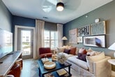 Located at 2700 N Lake Forest Dr in McKinney, TX, this thoughtfully designed 2-bedroom, 2-bathroom residence offers a well-organized single-story layout with a warm, contemporary aesthetic throughout. The open-concept living, dining, and kitchen area serves as the heart of the home, bathed in natural light from large windows with views of the surrounding community. The living room features a ceiling fan, bold accent walls in muted teal and blue tones, and direct access to an outdoor area. The kitchen is finished with light wood cabinetry, white quartz countertops, stainless steel appliances including a side-by-side refrigerator, a deep undermount sink with a matte black faucet, and gold pendant lighting. A dedicated dining area with built-in shelving completes the common living space. The primary bedroom is a serene retreat with a ceiling fan, warm-toned accent walls, natural light, and a walk-in closet outfitted with multi-level wire shelving. Its en-suite bathroom includes dual vanities with light wood cabinetry, a glass-enclosed walk-in shower with tile surround, and matte black hardware. The second bedroom echoes similar warmth with deep, rich wall tones. Additional highlights include four closets, a pantry, laundry, and a utility room.