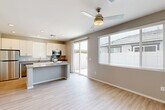 Located at 870 S Sarival Ave in Goodyear, Arizona, this single-story, 3-bedroom, 3-bathroom home offers a clean, modern aesthetic with a thoughtful layout. Light wood-look flooring flows throughout the space, complementing the neutral gray and white color palette found in every room.

The open-concept kitchen and living area forms the heart of the home. The kitchen is outfitted with white shaker-style cabinetry, quartz countertops, a central island, stainless steel appliances including a refrigerator, range, microwave, and dishwasher, and recessed lighting overhead. A sliding glass door and multiple windows with blinds fill the living area with natural light and provide access to the outdoors.

The three bedrooms are well-proportioned, each featuring ceiling fans or ventilation, neutral walls, and natural light from windows with blinds. The primary bedroom includes a dedicated walk-in closet with built-in wood shelving and hanging rods for ample storage. Two connecting hallways efficiently link the bedrooms and bathrooms.

Each of the three bathrooms maintains a consistent modern style, featuring light wood-look flooring, white vanities with quartz countertops, and clean, neutral finishes. The layout is practical and efficiently organized, making this home an ideal, move-in-ready residence in the Goodyear community.