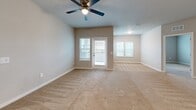 Located at 9940 Mahaffey Dr in Palmetto, FL, this single-story home offers three bedrooms and three bathrooms within a well-designed, modern floor plan. The open-concept kitchen and living area serves as the heart of the home, featuring rich dark-brown cabinetry extending to the ceiling, crisp white countertops, stainless steel appliances including a refrigerator, range, and microwave, and a large central island with pendant lighting overhead. Wood-look flooring anchors the kitchen, transitioning seamlessly to plush carpeting in the living and bedroom areas. The living room is generously sized, bathed in natural light from multiple windows with blinds, and finished with a ceiling fan for added comfort. Each bedroom offers soft carpeting, ceiling fans, and windows that bring in natural light and outdoor views. The primary bedroom is notably spacious, with two windows overlooking the surrounding landscape. The three bathrooms are finished in a clean, contemporary style with white shaker-style cabinetry, white countertops, and warm wood-look flooring. A dedicated closet adds practical storage to the layout. Neutral wall tones and consistent finishes throughout create a cohesive, move-in-ready atmosphere.
