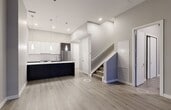 The View is a thoughtfully designed two-story residence offering three bedrooms and three bathrooms with a clean, contemporary aesthetic throughout. The main floor hosts an open-concept kitchen and living area finished with light hardwood-style flooring and neutral tones. The kitchen is a standout feature, showcasing a waterfall-edge quartz island with an undermount double sink, dark cabinetry, stainless steel appliances including a built-in dishwasher and full-size refrigerator, and elegant pendant lighting overhead. The living area benefits from soaring floor-to-ceiling windows that frame outdoor views and flood the space with natural light, creating an open and airy atmosphere. The upper floor accommodates the bedrooms, including a well-sized primary bedroom, each room continuing the hardwood-style flooring and neutral palette. Bedrooms feature organized closet systems with sliding doors. The three bathrooms are finished to a high standard, featuring marble-look tile, quartz countertops with undermount sinks, chrome fixtures, and glass-enclosed shower areas. One bathroom offers a deep soaker tub. Throughout both floors, the design emphasizes modern minimalism, quality materials, and a bright, cohesive aesthetic.