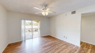 Located at 5500 NW 61st St in Coconut Creek, FL, this single-floor, 2-bedroom, 3-bathroom residence offers a functional and comfortable layout. The living room is a bright, open space featuring warm wood-look laminate flooring, a ceiling fan with light fixture, and a textured ceiling. Sliding glass doors lead to a private balcony, filling the room with natural light and providing outdoor views of the surrounding landscape. The kitchen is well-appointed with warm-toned wood cabinetry, granite countertops, white appliances including a refrigerator, range, microwave, and dishwasher, and classic white tile flooring. A pendant light adds a finishing touch to this functional cooking space. The primary bedroom is generously sized, with a ceiling fan, wood-look flooring, and a closet with louvered bifold doors. The second bedroom also features wood-look flooring, a ceiling fan, and a large window that brings in natural light and greenery views. The three bathrooms include granite-topped vanities with warm wood cabinetry and at least one tub/shower combination with white tile surround. Throughout the residence, neutral tones and consistent flooring create a cohesive, clean aesthetic.