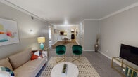 This single-floor residence offers a thoughtfully arranged layout that balances open communal spaces with comfortable private quarters. The living room is a welcoming focal point, featuring plush carpet flooring, crown molding, a textured ceiling, and a sliding glass door that fills the room with natural light. The space flows seamlessly into the dining area, which is defined by wood-look flooring, a pendant light overhead, and a pass-through window connecting directly to the kitchen — a practical detail that enhances the sense of openness. The kitchen is efficiently laid out in a galley style, equipped with white cabinetry, grey laminate countertops, a stainless steel sink, and black appliances including a refrigerator and dishwasher. Two bedrooms provide restful retreats, each with carpet flooring and neutral wall tones. The primary bedroom features dual sliding-door closets offering generous storage, while the secondary bedroom is well-sized and similarly appointed. A full bathroom serves the residence, complete with a white vanity, ample mirror space, and a shower with a curtain enclosure. Throughout the home, consistent neutral tones and crown molding details contribute to a clean, cohesive aesthetic.