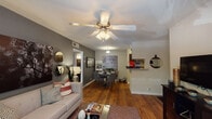 Located at 1500 Brentridge Dr in Nashville, TN, this single-floor residence offers a thoughtfully designed open-concept layout that seamlessly connects the living, dining, and kitchen areas. The living room features warm hardwood flooring, a ceiling fan with light fixture, and a bold accent wall adorned with large-scale artwork and decorative mirrors. A sliding glass door opens directly to a private outdoor balcony, bringing in natural light and views of surrounding greenery. The dining area flows naturally from the living space, creating an inviting atmosphere ideal for entertaining. The galley-style kitchen is well-appointed with dark espresso cabinetry, granite countertops, black appliances including a range and refrigerator, a subway tile backsplash, and a double-basin sink — all set over hardwood floors with ample upper and lower cabinet storage. The bedrooms are carpeted for comfort and each includes a ceiling fan, window treatments providing natural light, and generous space for furnishings. The primary bedroom features a deep accent wall that creates a warm, restful ambiance. Throughout the residence, a cohesive design palette of neutral tones, accent colors, and modern finishes contributes to a comfortable and stylish living environment.