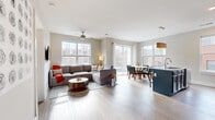 Located at 265 East State Street in downtown Columbus, this well-appointed 3-bedroom, 2-bathroom residence offers a thoughtfully designed single-floor layout. The open-concept living, dining, and kitchen area forms the heart of the home, bathed in natural light from large windows and a sliding glass door that leads to a balcony with views of the surrounding cityscape. Light-toned hardwood-style flooring flows throughout the main living area, complemented by a ceiling fan overhead. The kitchen is a standout feature, showcasing bold navy-blue cabinetry, granite countertops, a large island, stainless steel appliances, and a white subway tile backsplash. The dining area sits adjacent, framed by expansive windows with urban views. The three bedrooms are comfortably scaled, each featuring large windows that bring in natural light and city views. The primary bedroom offers a serene retreat with neutral tones. Both bathrooms are finished with navy vanity cabinetry, granite countertops, large mirrors, and walk-in glass-enclosed showers. In-unit laundry is also included. This residence combines modern urban living with functional design in a prime downtown Columbus location.