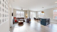 Located at 265 East State Street in downtown Columbus, this well-appointed 3-bedroom, 2-bathroom residence offers a thoughtfully designed single-floor layout. The open-concept living, dining, and kitchen area forms the heart of the home, bathed in natural light from large windows and a sliding glass door that leads to a balcony with views of the surrounding cityscape. Light-toned hardwood-style flooring flows throughout the main living area, complemented by a ceiling fan overhead. The kitchen is a standout feature, showcasing bold navy-blue cabinetry, granite countertops, a large island, stainless steel appliances, and a white subway tile backsplash. The dining area sits adjacent, framed by expansive windows with urban views. The three bedrooms are comfortably scaled, each featuring large windows that bring in natural light and city views. The primary bedroom offers a serene retreat with neutral tones. Both bathrooms are finished with navy vanity cabinetry, granite countertops, large mirrors, and walk-in glass-enclosed showers. In-unit laundry is also included. This residence combines modern urban living with functional design in a prime downtown Columbus location.