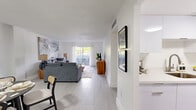 Located in Miami, FL, this well-appointed 2-bedroom, 1-bathroom single-floor home offers a clean, modern aesthetic with light tile flooring and crisp white walls throughout. The open-concept living and dining area forms the heart of the home, bathed in natural light from a sliding glass door that leads to a private balcony — ideal for enjoying Miami's warm climate. The living area provides generous space for comfortable seating and entertaining, while the adjacent dining nook offers a defined area for meals. The galley-style kitchen features white cabinetry, light quartz countertops, a stainless steel sink, and full appliances including a refrigerator and range, maximizing functionality within a compact layout. The spacious primary bedroom includes louvered closet doors and neutral tones, creating a calm retreat. The second bedroom is versatile and well-sized, with a window that draws in natural light. The bathroom is elegantly finished with marble-style wall surround tiles, a soaking tub with shower, and brushed nickel fixtures. Four closets throughout the home ensure ample storage. Textured ceilings and consistent flooring tie the space together for a cohesive, move-in-ready feel.