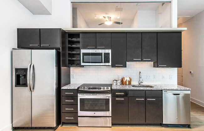 Renovated kitchen with granite countertops and stainless steel appliances - Lex and Leo at Waterfront Station