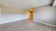 Located at 8501 Walther Blvd in Nottingham, MD, this one-bedroom, one-bathroom unit offers a practical and comfortable layout across a single floor. The living room provides a welcoming open feel, finished with light-toned wood-look flooring and neutral gray walls that create a clean, contemporary aesthetic. A window with vertical blinds allows natural light to brighten the space. The bedroom features plush carpeting underfoot, a window with horizontal blinds that invites outdoor light, and a closet for ample storage. The neutral tones throughout maintain a cohesive and calming atmosphere. The kitchen is a standout feature, equipped with rich dark wood cabinetry, granite countertops, a subway tile backsplash, and a stainless steel sink. Notably, it also accommodates in-unit washer and dryer hookups, adding significant everyday convenience. The bathroom is finished with tile-surround tub and shower combination, wood-look flooring, and a dark vanity that complements the overall design palette. Clean white trim and neutral wall tones tie each room together, presenting a move-in ready unit that balances modern updates with functional living in a compact, efficient footprint.