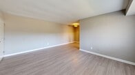 Located at 8501 Walther Blvd in Nottingham, MD, this one-bedroom, one-bathroom unit offers a practical and comfortable layout across a single floor. The living room provides a welcoming open feel, finished with light-toned wood-look flooring and neutral gray walls that create a clean, contemporary aesthetic. A window with vertical blinds allows natural light to brighten the space. The bedroom features plush carpeting underfoot, a window with horizontal blinds that invites outdoor light, and a closet for ample storage. The neutral tones throughout maintain a cohesive and calming atmosphere. The kitchen is a standout feature, equipped with rich dark wood cabinetry, granite countertops, a subway tile backsplash, and a stainless steel sink. Notably, it also accommodates in-unit washer and dryer hookups, adding significant everyday convenience. The bathroom is finished with tile-surround tub and shower combination, wood-look flooring, and a dark vanity that complements the overall design palette. Clean white trim and neutral wall tones tie each room together, presenting a move-in ready unit that balances modern updates with functional living in a compact, efficient footprint.