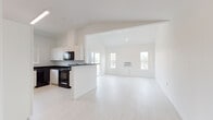 Located on the third floor at 16618 East Broadway Avenue in Spokane Valley, WA, Unit A307 is a thoughtfully designed multi-bedroom residence offering a clean, modern aesthetic throughout. The open-concept living and kitchen area serves as the heart of the unit, featuring light luxury vinyl plank flooring, vaulted ceilings, and an abundance of natural light from multiple windows. Sliding glass doors lead to a private balcony with outdoor views of the surrounding neighborhood and greenery.

The kitchen is well-appointed with white cabinetry, dark granite-style countertops, and a full suite of black appliances including a refrigerator, electric range, built-in microwave, and dishwasher. A peninsula provides additional workspace and separation from the living area.

The bedrooms offer comfortable accommodations, with carpeted flooring and large windows that bring in natural light and outdoor views. Closet space is available, including a walk-in closet in one of the bedrooms.

The bathrooms are finished with white cabinetry, dark countertops, and light vinyl plank flooring, maintaining the unit's cohesive color palette. One bathroom includes a tub/shower combination, while another offers a more compact layout. The unit's crisp white walls and consistent finishes create a bright, clean, and move-in-ready living environment.