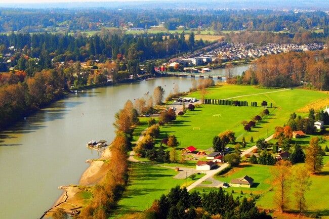Aerial view of Langley with the Fraser River winding through lush farmland.