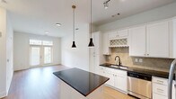 Located at 1226 Parktop Dr in Cary, NC, this well-appointed one-bedroom, one-bathroom residence offers a thoughtfully designed single-floor layout. Light hardwood-style flooring flows consistently throughout the space, creating a clean and cohesive aesthetic.

The open-concept kitchen and living area serves as the heart of the home. The kitchen is outfitted with crisp white shaker cabinetry featuring gold hardware, dark granite countertops, a tiled backsplash, and a full suite of stainless steel appliances including a range, built-in microwave, and French door refrigerator. A central island with pendant lighting above provides additional prep space and casual seating. The adjacent living area receives natural light through glass French doors that open to an outdoor view.

The primary bedroom is a comfortable, well-lit retreat with large windows overlooking a landscaped exterior, a ceiling fan, and direct access to a dedicated walk-in closet with built-in shelving. The full bathroom features a soaking tub with a tiled surround accented by a decorative mosaic border, complemented by tile flooring in warm neutral tones. A separate, dedicated laundry room accommodates a full-size side-by-side washer and dryer. Throughout, the space maintains a bright, neutral palette ideal for a variety of furnishing styles.