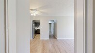 This single-floor, 2-bedroom, 1-bathroom residence offers a practical and thoughtfully arranged layout across a comfortable footprint. The home is accessed through a dedicated entrance and flows through connecting hallways to each area of the unit.

The kitchen is a functional highlight, featuring dark gray shaker-style cabinetry, light marble-look countertops, stainless steel appliances including a gas range, dishwasher, and refrigerator, all set over durable light wood-look flooring. The kitchen connects seamlessly to the living room, which is bright and open, featuring the same wood-look flooring and neutral warm-toned walls.

Both bedrooms are carpeted and finished with the same neutral palette, offering a calm and restful atmosphere. Each bedroom benefits from natural light through windows with exterior views. The primary bedroom is generously sized and includes access to a dedicated walk-in closet outfitted with dual hanging rods and shelving on carpet flooring.

The full bathroom is clean and well-appointed, with a dark-cabinet vanity, white countertop, a full tub-shower combination, and wood-look tile flooring. Throughout the home, consistent neutral tones, textured ceilings, and clean white trim contribute to a cohesive and move-in ready aesthetic.
