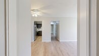 This single-floor, 2-bedroom, 1-bathroom residence offers a practical and thoughtfully arranged layout across a comfortable footprint. The home is accessed through a dedicated entrance and flows through connecting hallways to each area of the unit.

The kitchen is a functional highlight, featuring dark gray shaker-style cabinetry, light marble-look countertops, stainless steel appliances including a gas range, dishwasher, and refrigerator, all set over durable light wood-look flooring. The kitchen connects seamlessly to the living room, which is bright and open, featuring the same wood-look flooring and neutral warm-toned walls.

Both bedrooms are carpeted and finished with the same neutral palette, offering a calm and restful atmosphere. Each bedroom benefits from natural light through windows with exterior views. The primary bedroom is generously sized and includes access to a dedicated walk-in closet outfitted with dual hanging rods and shelving on carpet flooring.

The full bathroom is clean and well-appointed, with a dark-cabinet vanity, white countertop, a full tub-shower combination, and wood-look tile flooring. Throughout the home, consistent neutral tones, textured ceilings, and clean white trim contribute to a cohesive and move-in ready aesthetic.