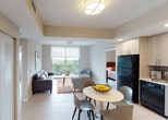 Located at 28250 S Dixie Hwy in Homestead, Florida, this thoughtfully designed single-floor residence offers a seamless blend of modern style and functional living. The open-concept layout connects the living, dining, and kitchen areas, creating an inviting and efficient flow throughout the space. Large sliding glass doors in the living room flood the area with natural light and lead to a private balcony overlooking lush tree canopies and the surrounding neighborhood — an ideal spot for relaxing or enjoying the South Florida outdoors.

The kitchen is a standout feature, equipped with light wood cabinetry extending to the ceiling, white countertops, a tile backsplash, and a full suite of black appliances including a refrigerator, range, microwave, and dishwasher. Recessed lighting enhances the clean, contemporary aesthetic.

The bedrooms are comfortably sized, with large windows framing verdant outdoor views, neutral-toned walls, and walk-in closet access. Light hardwood-style flooring adds warmth and continuity to the private spaces. The bathroom is well-appointed, featuring a wide vanity with a white countertop, wood-tone cabinetry, a large mirror, and a tub-shower combination with floor-to-ceiling tile surround. Light tile flooring runs throughout the main living areas, tying the entire space together with a cohesive, modern finish.