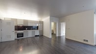 Located at 3015 San Pablo Ave in Berkeley, California, this single-floor unit offers a clean, contemporary design with thoughtful finishes throughout. Dark hardwood flooring runs continuously across the open-concept living and dining area, creating a cohesive and polished aesthetic. Large windows invite abundant natural light into the main living space, providing views of the surrounding neighborhood.

The modern kitchen is well-appointed with sleek gray cabinetry, a dark tile backsplash, light countertops, a gas cooktop, built-in oven, and a stainless steel sink. A dedicated in-unit laundry closet with a stacked washer and dryer is conveniently accessible just off the kitchen area.

The bedroom is bright and generously proportioned, featuring a large window that brings in natural light and outdoor views. A spacious walk-in closet with wire shelving provides ample storage. The bathroom is finished in a clean, contemporary style with white subway tile surrounding the full bathtub and shower, a large vanity mirror, white cabinetry with drawers, and dark mosaic floor tile. The overall design of the unit emphasizes modern minimalism, with white walls, clean lines, and functional spaces throughout.