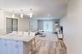 Located at 200 La Bonne Vie Dr in East Patchogue, NY, this well-appointed 2-bedroom, 1-bathroom residence offers a thoughtfully designed single-floor layout with a clean, modern aesthetic throughout. The open-concept kitchen and living area serves as the heart of the home, where crisp white shaker cabinetry, granite countertops, and stainless steel appliances define a stylish, functional kitchen anchored by a peninsula with bar seating. Pendant lighting accents the space, which flows seamlessly into a spacious living room finished with light hardwood-style flooring, recessed lighting, and a sliding glass door that invites natural light and outdoor views. The generously sized primary bedroom features plush carpeting, a ceiling fan, and a window unit, while the second bedroom mirrors a similar comfortable feel with its own ceiling fan and ample natural light. Three closets provide excellent storage throughout. The full bathroom is elegantly finished with large-format neutral tile surrounding a soaking tub and shower, complemented by a granite vanity top. Neutral tones, recessed lighting, and consistent finishes create a cohesive, move-in-ready atmosphere throughout this well-maintained residence.