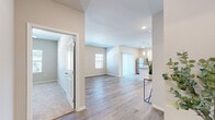 Located at 101 North West Mock Avenue in Blue Springs, Missouri, this single-floor, 2-bedroom, 2-bathroom home offers a thoughtfully designed layout with modern finishes throughout. The open-concept living and kitchen area is anchored by light-toned luxury vinyl plank flooring that flows seamlessly through the main spaces, creating a bright and cohesive feel. Natural light filters in through multiple windows dressed with clean white blinds, enhancing the home's airy atmosphere.

The kitchen is a standout feature, showcasing white shaker-style cabinetry, granite countertops, a central island with additional seating and prep space, stainless steel appliances, and elegant pendant lighting overhead. Both bathrooms continue the granite countertop theme with white cabinetry and wood-look flooring, with one bathroom offering direct access to a spacious walk-in closet equipped with wire shelving.

The primary bedroom is generously sized and features plush carpeting, a ceiling fan, and a window with outdoor views. The second bedroom also offers carpet flooring and ample natural light. An additional room with wood-look flooring provides flexible use as a bedroom or office. Neutral, warm-toned walls throughout the home create a clean and versatile backdrop, making this a move-in ready residence.