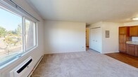 Located at 540 E 13 Mile Rd in Madison Heights, Michigan, this two-bedroom, one-bathroom residence offers a practical and well-organized single-floor layout. The kitchen is a functional highlight, featuring warm honey-toned cabinetry, light granite-style countertops, hardwood-style flooring, and a full suite of stainless steel appliances including an electric range with overhead ventilation, a dishwasher, and a refrigerator — providing ample storage and workspace for everyday cooking. The living room is bright and carpeted, with a window that invites natural light and includes a wall-unit air conditioner and baseboard heating for year-round comfort. Both bedrooms are carpeted and feature ceiling fans with integrated lighting, vertical blind-covered windows, and generous closet space with bifold doors. The primary bedroom is comfortably sized and offers an additional closet for storage. The bathroom is clean and straightforward, equipped with a full tub-shower combination with a curtain rod. Throughout the residence, baseboard heating is present in key rooms, ensuring efficient temperature control. The overall ambiance is light, neutral, and move-in ready.
