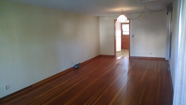 Sala de estar con vista a la cocina y entrada trasera. - 507 N Division Ave