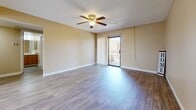 Located at 9415 N 99th Ave in Peoria, Arizona, this single-story, 3-bedroom, 3-bathroom home offers a functional and comfortable layout. The living room is a bright, open space featuring wood-look laminate flooring, a ceiling fan with light fixture, and a sliding glass door that opens to an outdoor patio, allowing natural light to flow freely throughout. An adjacent window provides additional views of the surrounding greenery.

The galley-style kitchen is efficiently designed with warm wood-toned cabinetry, ample upper and lower storage, white appliances including a range and refrigerator, a built-in dishwasher, and a window above the sink for natural light.

Each of the three bedrooms is finished with plush carpeting and ceiling fans. The primary bedroom includes a sliding-door closet and a window overlooking the outdoors. The additional bedrooms are similarly appointed with windows that bring in natural light. All three bathrooms feature tub-shower combinations with grab bars and wood-look flooring, offering both practicality and comfort.

Throughout the home, warm beige tones and textured ceilings create a cohesive, understated aesthetic. A dedicated hallway and closet add to the home's organizational efficiency, making this Peoria residence a well-rounded and livable space.