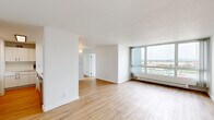 Located at 1130 E 3rd Avenue in Oakland, CA, this 2-bedroom, 1-bathroom residence offers a well-designed layout with a thoughtful blend of modern updates and comfortable living spaces. The open living room is a standout feature, bathed in natural light from expansive floor-to-ceiling windows that frame sweeping views of the Oakland cityscape and the bay beyond, creating a bright and airy atmosphere throughout the day.

The kitchen has been tastefully updated with crisp white cabinetry accented by sleek black hardware, light wood-style flooring, and generous quartz countertops featuring an undermount stainless steel sink with a matte black faucet. Stainless steel appliances, including a refrigerator, electric range, and dishwasher, complete the functional and stylish cooking space.

Both bedrooms are well-proportioned and serene. The primary bedroom features a sliding closet and the same warm wood-style flooring found throughout the main living areas. The secondary bedroom is carpeted and benefits from large windows offering the same impressive elevated views. The full bathroom is clean and modern, featuring a white vanity with a stone-topped sink, matte black fixtures, and warm wood-style flooring that ties the space together cohesively.