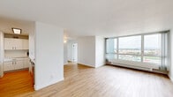 Located at 1130 E 3rd Avenue in Oakland, CA, this 2-bedroom, 1-bathroom residence offers a well-designed layout with a thoughtful blend of modern updates and comfortable living spaces. The open living room is a standout feature, bathed in natural light from expansive floor-to-ceiling windows that frame sweeping views of the Oakland cityscape and the bay beyond, creating a bright and airy atmosphere throughout the day.

The kitchen has been tastefully updated with crisp white cabinetry accented by sleek black hardware, light wood-style flooring, and generous quartz countertops featuring an undermount stainless steel sink with a matte black faucet. Stainless steel appliances, including a refrigerator, electric range, and dishwasher, complete the functional and stylish cooking space.

Both bedrooms are well-proportioned and serene. The primary bedroom features a sliding closet and the same warm wood-style flooring found throughout the main living areas. The secondary bedroom is carpeted and benefits from large windows offering the same impressive elevated views. The full bathroom is clean and modern, featuring a white vanity with a stone-topped sink, matte black fixtures, and warm wood-style flooring that ties the space together cohesively.
