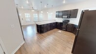 This 710 square foot single-story residence in Corpus Christi, TX, offers a compact yet well-designed living space. The home features one bedroom and one bathroom, with the primary bedroom measuring a spacious 180 square feet. The interior showcases a modern aesthetic with a blend of hardwood and carpeted flooring throughout.

The kitchen is a standout feature, boasting dark wood cabinetry, granite countertops, and matching appliances, creating a sleek and cohesive look. The open-concept design seamlessly integrates the kitchen with the living area, enhancing the sense of space and facilitating easy entertainment.

Large windows with horizontal blinds are present in most rooms, allowing ample natural light to flood the space. The bathroom is equipped with contemporary fixtures, including a combination bathtub and shower. The laundry room comes complete with a washer and dryer set.

Ceiling fans in the bedroom and living area provide additional comfort and air circulation. The property also includes two closets for added storage. Overall, this home offers a balanced combination of style, functionality, and comfort in a manageable size.
