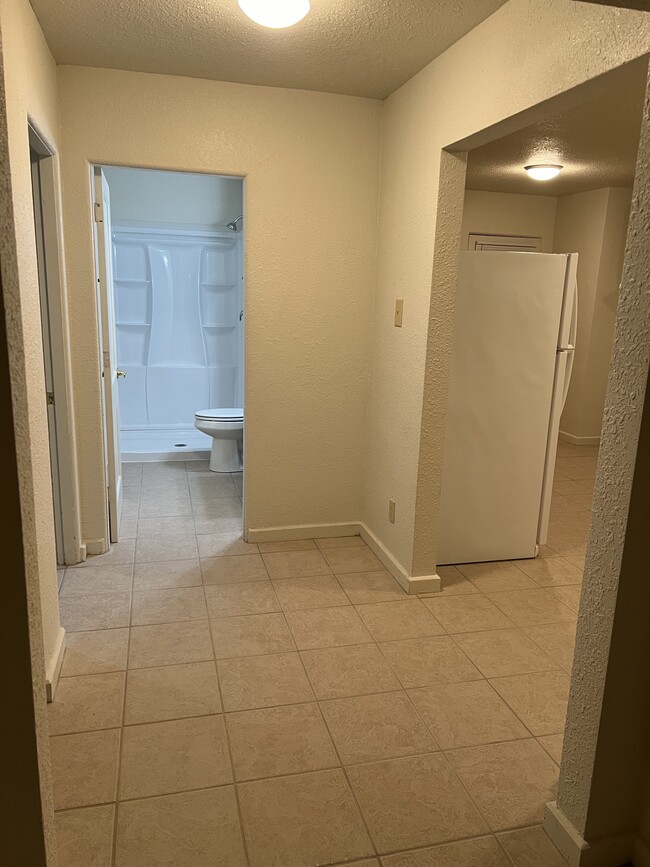Hallway to bedroom (left), bathroom (straight) and kitchen (right). - 217 N 1st St
