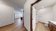 Located in Olympia, Washington, this single-floor, 2-bedroom, 2-bathroom residence offers a practical and comfortable layout designed for everyday living. The kitchen is a standout feature, equipped with rich dark-wood cabinetry, light stone countertops, a full suite of stainless steel appliances including a refrigerator, electric range, built-in microwave, and dishwasher, all complemented by warm wood-look flooring and a central island for additional prep space. The open layout connects the kitchen seamlessly to the main living area. Both bedrooms feature soft, neutral carpet, dark wood baseboards, and windows that invite natural light and views of the surrounding greenery. The primary bedroom includes a dedicated closet, while a hallway connects to both bathrooms, each outfitted with a full tub-shower combination, wood-look flooring, and clean white fixtures. Crisp white panel doors with brushed nickel hardware are consistent throughout the unit, contributing to a cohesive, modern aesthetic. The neutral color palette and clean finishes create a bright, move-in-ready atmosphere suited for a variety of living arrangements.