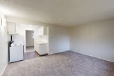 Located at 922 N Pearl St in Tacoma, WA, this one-bedroom, one-bathroom unit offers a well-organized single-floor layout designed for efficient everyday living. The carpeted living room serves as the main gathering space, featuring a large window that invites natural light and provides outdoor views, along with a baseboard heating system and a welcoming entry door. The open pass-through connects the living area to the kitchen, which is finished with hardwood-style flooring, white cabinetry, a coil-burner electric range with overhead ventilation, a full-size refrigerator, and a sink with countertop workspace — providing all the essentials for meal preparation. The bedroom is a comfortably sized, carpeted retreat with its own window for natural light and ventilation, complemented by baseboard heating. Accessible from the bedroom area, the full bathroom is finished in a clean, white palette and includes a shower/tub combination, a toilet, a vanity with sink, and a wall-mounted mirror with overhead lighting. An electrical panel is conveniently located in the hallway between rooms. Textured ceilings are consistent throughout the unit, contributing to its functional and straightforward character.