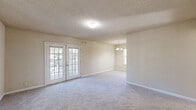 Located at 3954 Memorial College Ave in Clarkston, Georgia, this single-floor residence offers a well-organized layout with comfortable living spaces throughout. The expansive living area is carpeted and filled with natural light, highlighted by a set of classic French doors that open to the outdoors, creating a seamless connection between interior and exterior. Adjacent to the living area is a dining space appointed with an elegant chandelier and a window that brings in additional daylight. The galley-style kitchen is efficiently designed with warm wood-toned cabinetry, a double-basin sink, a dishwasher, and a full-size refrigerator, all set on easy-to-maintain hardwood-style flooring. The bedrooms are generously proportioned, featuring plush carpeting, textured ceilings, ample closet space, and windows that allow natural light to flow in. The bathroom is clean and functional, complete with a tub and shower combination. Throughout the home, neutral tones and white trim create a bright, cohesive aesthetic. Textured ceilings are consistent across all rooms, adding a classic residential character to the space.