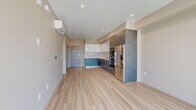 This modern 1-bedroom, 1-bathroom residence in Roseville, CA offers a well-designed open-concept layout with contemporary finishes throughout. Light hardwood flooring flows seamlessly across the entire unit, creating a cohesive and airy feel.

The kitchen and living area form the heart of the home, showcasing a sleek, modern kitchen outfitted with two-tone cabinetry — white upper cabinets contrasted by dark slate-finish lower cabinets — paired with light quartz countertops and a clean white tile backsplash. Stainless steel appliances, including a double wall oven and a full-size refrigerator, add functionality and style. A wall-mounted mini-split HVAC unit provides efficient climate control.

The living area opens directly to a private balcony through expansive floor-to-ceiling sliding glass doors, filling the space with abundant natural light and offering views of the surrounding neighborhood. The generously sized bedroom also features a large window with outdoor views and includes a dedicated closet with built-in shelving for organized storage.

The bathroom is clean and functional, featuring a full soaking tub with a shower, a curved rod, and a neutral warm-toned palette. A hallway connects all rooms efficiently, with an additional closet providing extra storage. Recessed lighting throughout completes the polished, modern aesthetic of this thoughtfully designed residence.