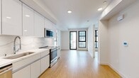 Located at 1641 Lincoln Blvd, Unit 408, in Santa Monica, CA, this modern 2-bedroom, 2-bathroom apartment offers 610 square feet of thoughtfully designed living space. The unit features warm bamboo hardwood flooring throughout, crisp white walls, and recessed lighting that create a clean, contemporary aesthetic.

The galley-style kitchen is outfitted with high-gloss white cabinetry extending to the ceiling, a marble-look backsplash, white quartz countertops, and a full suite of stainless steel appliances including a refrigerator, electric range, dishwasher, and built-in microwave. Both bedrooms are bright and airy, each equipped with ceiling fans and large black-framed picture windows that allow abundant natural light and views of the surrounding building courtyard. The primary bedroom measures 110 square feet, while the second bedroom features a sliding closet door for added storage.

The bathrooms are finished with marble hexagon tile flooring and gold-toned hardware, with one bathroom featuring a soaking tub and shower combination. A dedicated in-unit laundry closet houses a stacked full-size washer and dryer, adding everyday convenience to this well-appointed Santa Monica residence.