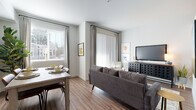 This single-floor residence is thoughtfully designed with a clean, contemporary aesthetic evident throughout each space. The kitchen is outfitted with stainless steel appliances, including a full-size refrigerator, electric range, and over-the-range microwave, all set against crisp white cabinetry with modern hardware. Track lighting illuminates the galley-style layout, which flows seamlessly into adjacent living areas. Wood-style plank flooring carries through the kitchen, living, and dining areas, lending visual continuity and a warm, modern feel. The open living and dining area benefits from multiple windows fitted with horizontal blinds and floor-length draping, allowing natural light to filter in while maintaining privacy. A sliding glass door provides access to an outdoor space, further enhancing the bright, airy atmosphere. The bedroom features plush carpet flooring and recessed lighting, creating a calm, restful environment, with a walk-in closet offering organized shelving. A hallway with additional closet space connects the bedroom to the rest of the unit. The bathroom includes a soaking tub with shower, a single-sink vanity with mirror, and wood-style flooring. Overall, the residence presents a cohesive, well-appointed interior suited for comfortable everyday living.
