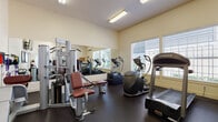 This well-equipped fitness center at 9511 NE Hazel Dell Ave in Vancouver, Washington, offers a comprehensive workout environment designed to support a wide range of exercise routines. The single-floor facility features high ceilings that lend an open, airy feel, while large windows with horizontal blinds allow ample natural light to fill the space throughout the day.

The gym is outfitted with a strong selection of cardio equipment, including a Landice treadmill, elliptical trainers, and a stationary bike, all positioned to take advantage of the natural light and outdoor views. A full-length wall mirror expands the sense of space and allows users to monitor their form during workouts.

For strength training, the facility includes a multi-function cable machine with an adjustable bench, a power tower for pull-ups and dips, a rack of dumbbells, medicine balls, and resistance bands mounted conveniently on the wall. A wall-mounted flat-screen television provides entertainment during workouts.

The floor is covered in durable dark rubber flooring suited for high-impact use, and the neutral cream-colored walls keep the environment clean and focused. A bulletin board and coat hooks near the entry door add practical touches, while a sanitation station ensures a hygienic environment. Overall, the space is thoughtfully organized to maximize functionality and comfort for users of all fitness levels.