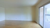 This single-floor space presents a clean, minimalist aesthetic that provides a welcoming and functional environment. The interior is defined by smooth, white walls that reflect natural light, creating a bright and airy atmosphere throughout. Light-toned hardwood flooring runs consistently across the space, adding warmth and a timeless quality to the overall design. The flooring's natural grain and pale finish complement the neutral wall palette, contributing to a cohesive and open feel. A window along one wall allows natural light to filter into the space, further enhancing its sense of openness. Electrical outlets are conveniently positioned along the walls, offering practical utility for a variety of uses. The space's straightforward layout and uncluttered design make it highly adaptable, suitable for a range of configurations and purposes. The combination of hardwood floors, white walls, and natural light gives the space a fresh, move-in-ready quality that serves as an excellent blank canvas for customization.
