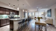 This thoughtfully designed 2-bedroom, 2-bathroom residence offers a comfortable and functional single-floor layout. The open-concept kitchen and living area serves as the heart of the home, featuring rich dark cabinetry, granite countertops, a tile backsplash, and stainless steel appliances. A generously sized kitchen island with bar seating and elegant pendant lighting makes it ideal for both casual dining and entertaining. Wood-look flooring flows throughout the main living areas, adding warmth and continuity to the space.

The living room extends naturally from the kitchen, bathed in natural light through large windows with blinds, and includes a ceiling fan overhead. Both bedrooms are carpeted and well-proportioned, each benefiting from natural light and ceiling fans. The primary bedroom includes access to a spacious walk-in closet outfitted with wire shelving systems for ample storage. A second closet provides additional organization options.

The two bathrooms are finished with granite vanity countertops, dark cabinetry, wood-look tile flooring, and a full tub-shower combination. Two hallways connect the rooms efficiently throughout the layout. Overall, the residence presents a modern, cohesive aesthetic with quality finishes, practical storage, and a bright, welcoming atmosphere throughout.