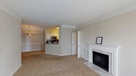 Located at 3301 Cotton Mill Dr in Raleigh, NC, this single-floor residence offers a well-designed layout with a comfortable, cohesive ambiance throughout. The open living area serves as the heart of the home, highlighted by a classic white-mantled fireplace with a striking marble surround and hearth, adding an elegant focal point to the carpeted main space. Crown molding details and a textured ceiling lend traditional character to the room.

The kitchen is thoughtfully positioned adjacent to the living area with a pass-through bar, providing both functionality and an open feel. It features white shaker-style cabinetry, dark granite countertops, a gray tile backsplash, and stainless steel appliances, including an electric range and over-the-range microwave.

The bedroom is generously proportioned, featuring a tray ceiling that adds architectural depth, neutral carpet, and a large window that allows ample natural light. Two walk-in closets provide exceptional storage, each outfitted with wire shelving systems along multiple walls for organized, flexible use.

The bathroom is clean and practical, featuring a tub-shower combination with classic white tile accented by bold red tile inlays, a vanity with a large mirror, and hardwood-style flooring. The overall palette throughout the home is neutral and inviting, offering a versatile canvas for any interior style.